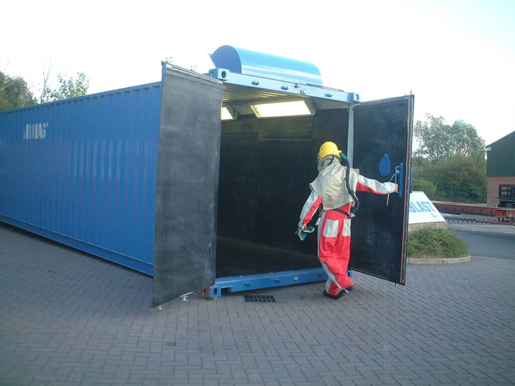 Operator opening the hinge door's to enter a Airblast containerised blasting room.