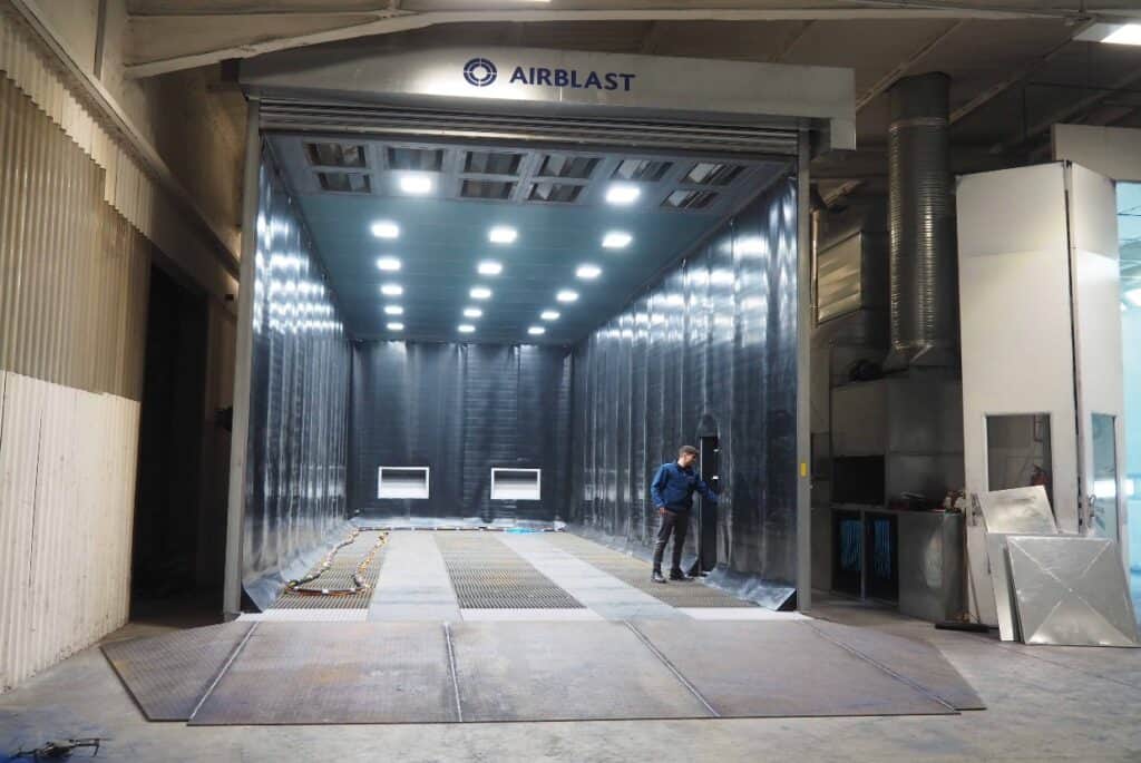 Airblast blast room at K-two manufacturing facility, featuring a full recovery floor, ATEX lighting, and roller door.