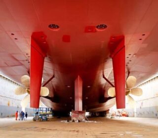 Underside of a freight ship in a dry dock.