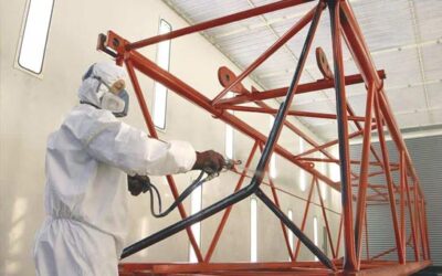 Paint sprayer in a spray room spray coating a steel structure.