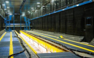 Blast room at bombardier transport (acquired by Alstom, 2021), with a central trench, rails, and moveable access scaffold to process rolling stock.