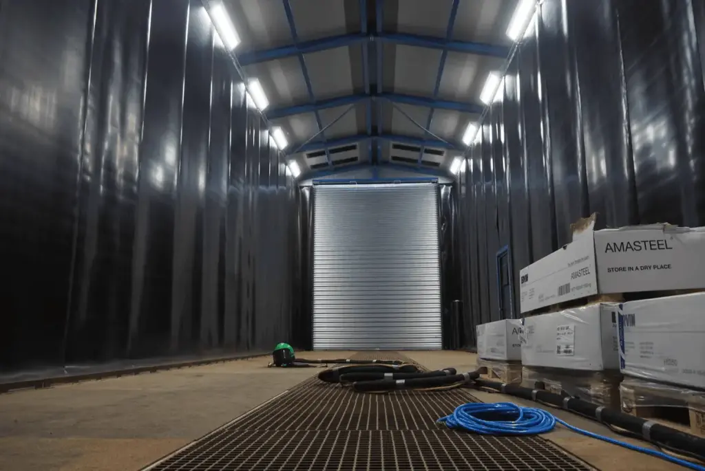 he enclosure of a surface treatment facility where blasting takes place.