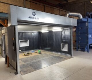 The blast room enclosure at Hydro International, it's roller door open, showing the interior.