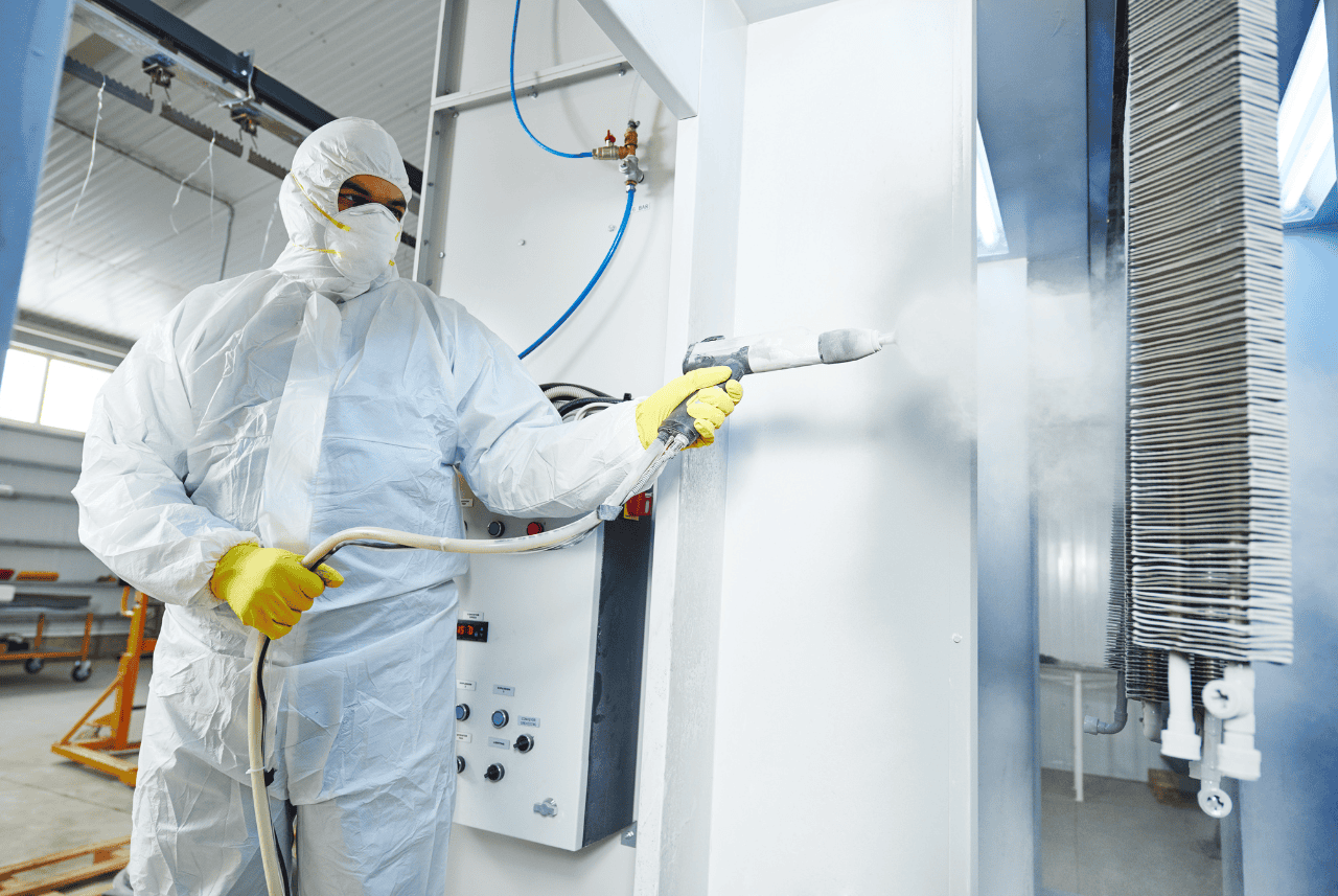 Worker in an industrial setting completing powder coating.